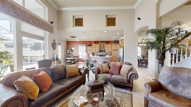 living area with a high ceiling, crown molding, and light tile patterned flooring