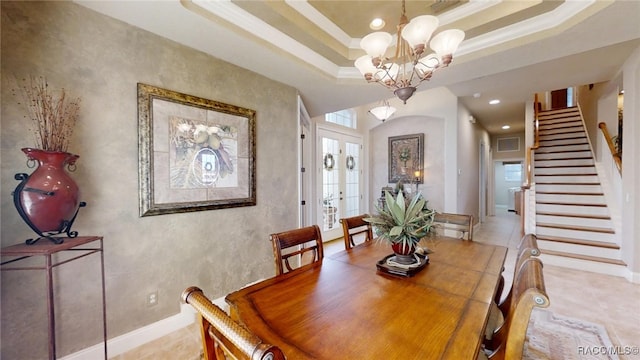 dining space with a tray ceiling, french doors, crown molding, stairway, and a chandelier