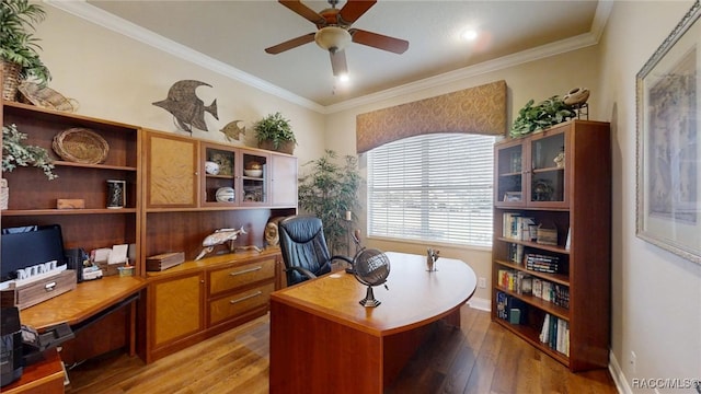 office area featuring light wood-style floors, ornamental molding, baseboards, and a ceiling fan