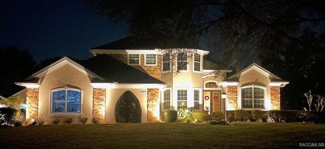 view of front of home featuring stone siding and a yard