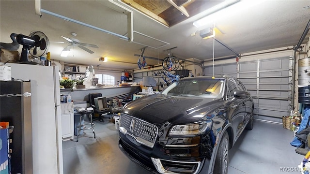 garage featuring a garage door opener, a ceiling fan, and freestanding refrigerator