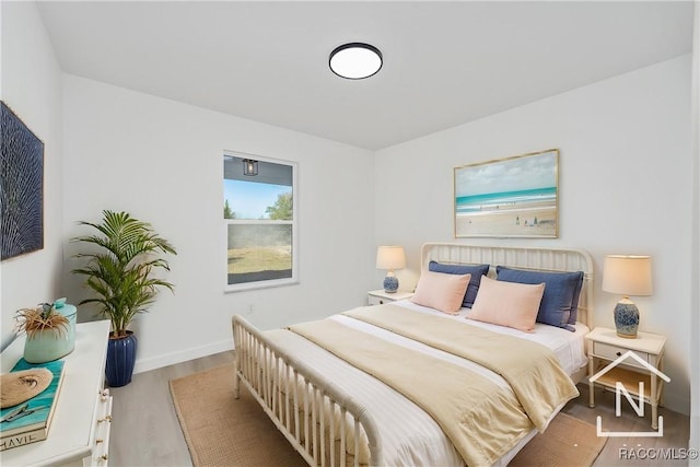 bedroom with baseboards and wood finished floors