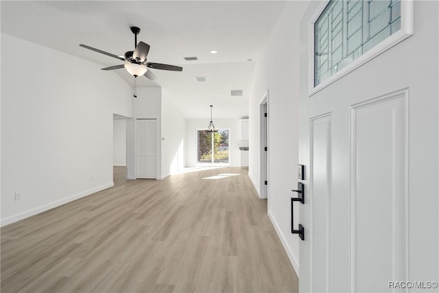 living room with light wood-style flooring, visible vents, baseboards, and ceiling fan with notable chandelier