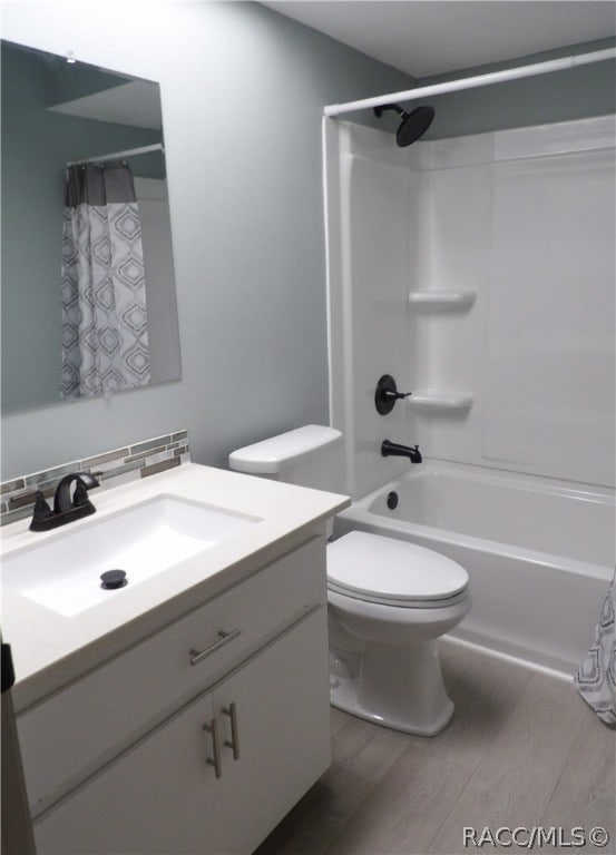 full bathroom featuring toilet, vanity, shower / tub combo with curtain, and hardwood / wood-style flooring