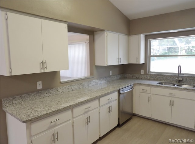 kitchen featuring dishwasher, sink, vaulted ceiling, white cabinets, and light wood-type flooring