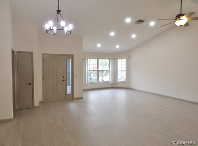 foyer entrance featuring ceiling fan with notable chandelier, light hardwood / wood-style floors, and lofted ceiling