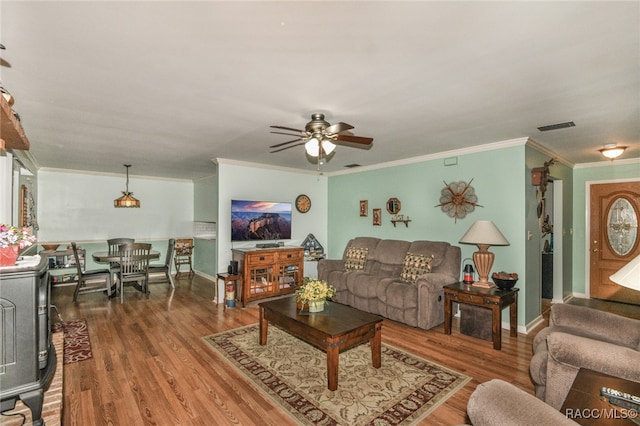 living room with wood-type flooring, ceiling fan, and crown molding