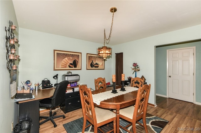 dining room with hardwood / wood-style flooring and a chandelier