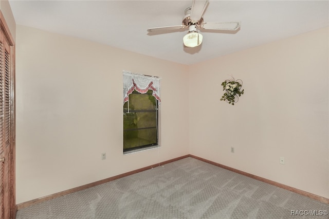 carpeted spare room with ceiling fan