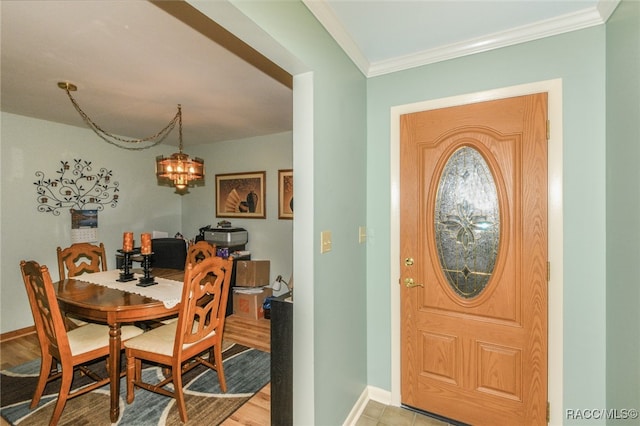 dining room with a notable chandelier, light wood-type flooring, and ornamental molding