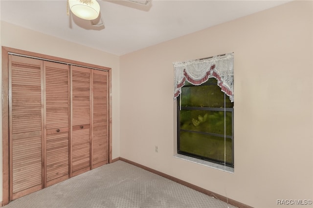 unfurnished bedroom with ceiling fan, a closet, and carpet