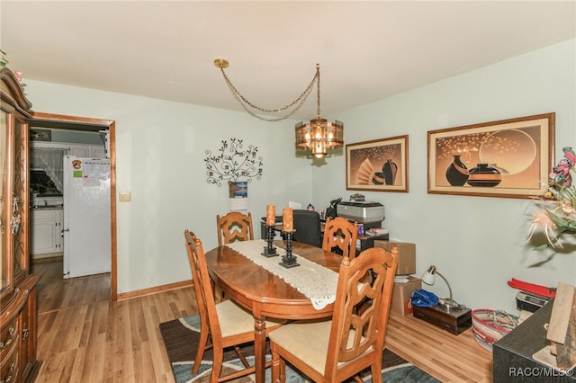 dining space featuring an inviting chandelier and hardwood / wood-style flooring