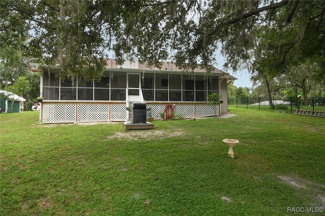 back of house with a yard and a sunroom