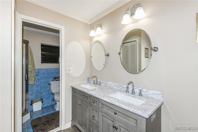 bathroom with vanity, tile patterned floors, toilet, ornamental molding, and tile walls