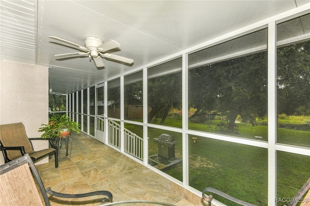 unfurnished sunroom with ceiling fan