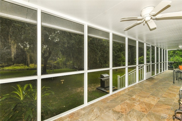 unfurnished sunroom featuring ceiling fan