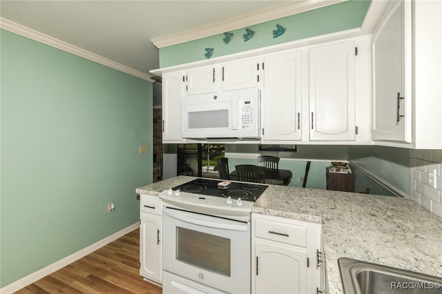 kitchen featuring white appliances, white cabinets, ornamental molding, light stone counters, and wood-type flooring