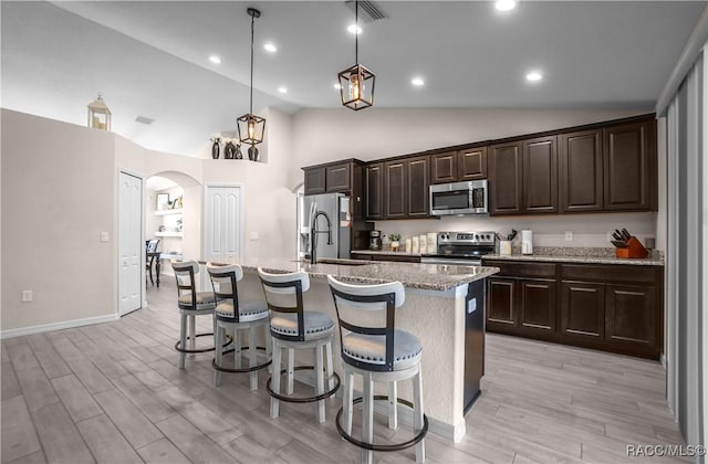 kitchen featuring decorative light fixtures, an island with sink, sink, a kitchen bar, and stainless steel appliances