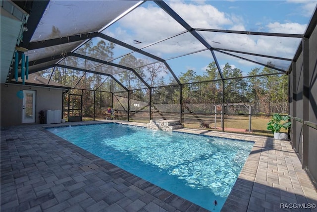 view of pool featuring a patio, pool water feature, and glass enclosure