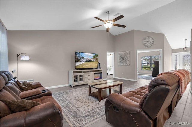 living room with lofted ceiling, ceiling fan, and light hardwood / wood-style flooring