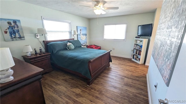 bedroom with ceiling fan, dark hardwood / wood-style floors, and a textured ceiling