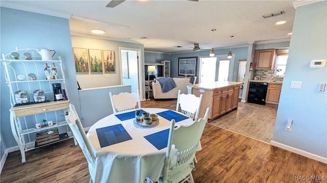 dining space with dark hardwood / wood-style flooring, ornamental molding, and ceiling fan