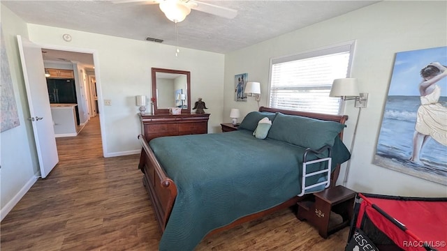 bedroom featuring ceiling fan, dark hardwood / wood-style floors, and a textured ceiling