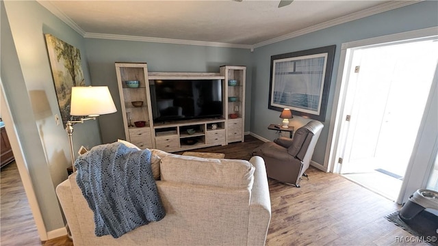 living room with wood-type flooring, ornamental molding, and ceiling fan