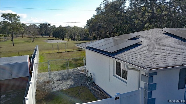 view of side of home featuring a lawn and solar panels