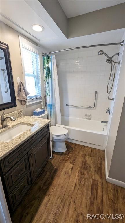 full bathroom with vanity, hardwood / wood-style flooring, toilet, and shower / bath combo with shower curtain