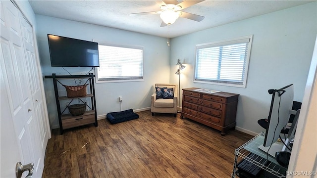 living area with ceiling fan, a healthy amount of sunlight, and dark hardwood / wood-style floors