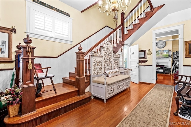 staircase with hardwood / wood-style flooring and an inviting chandelier