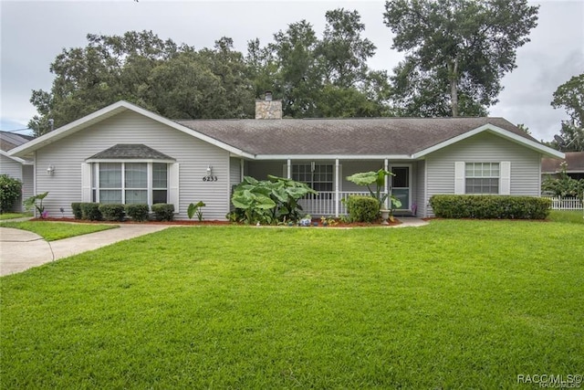 ranch-style house with a front lawn, a shingled roof, a porch, and a chimney
