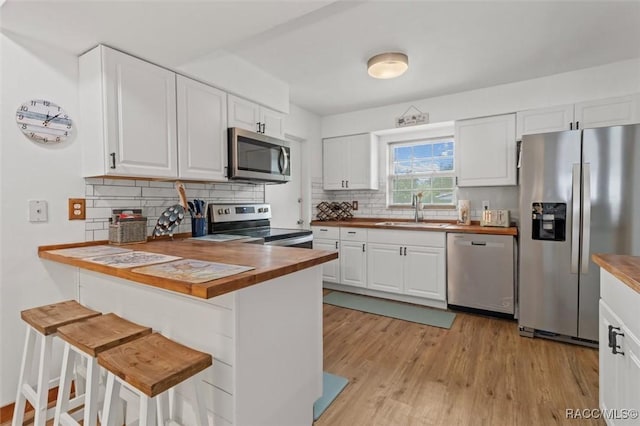 9125 N Abbot Dr, Citrus Springs, FL 34434 - kitchen featuring appliances with stainless steel finishes, a sink, wood counters, tasteful backsplash, and white cabinets