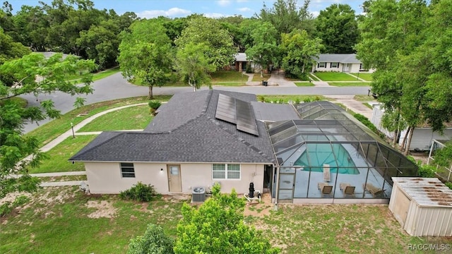 9125 N Abbot Dr, Citrus Springs, FL 34434 - back of house with a shingled roof, stucco siding, an outdoor pool, glass enclosure, and a yard