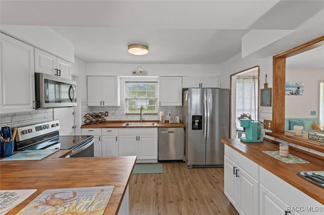 9125 N Abbot Dr, Citrus Springs, FL 34434 - kitchen featuring butcher block countertops, stainless steel appliances, a sink, and tasteful backsplash