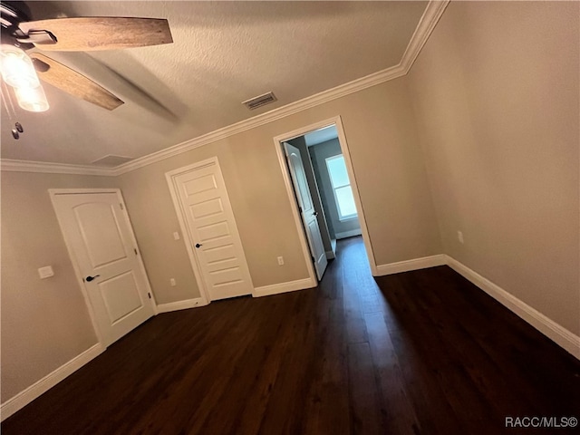 spare room featuring crown molding, ceiling fan, dark wood-type flooring, and a textured ceiling