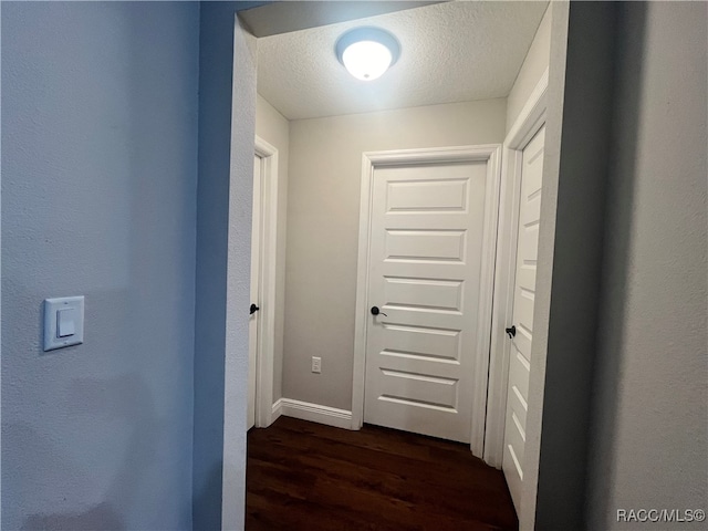 hall with dark hardwood / wood-style floors and a textured ceiling