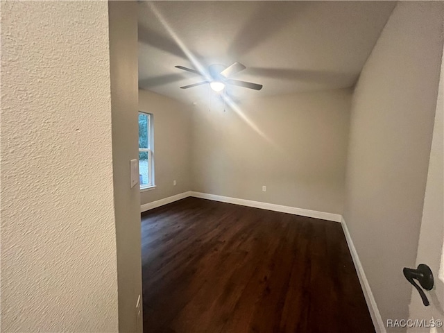 spare room with dark hardwood / wood-style floors and ceiling fan