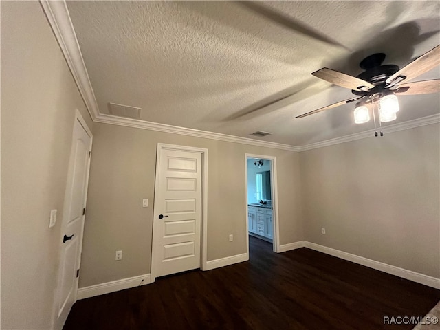 unfurnished bedroom with ensuite bath, ceiling fan, dark hardwood / wood-style floors, crown molding, and a textured ceiling