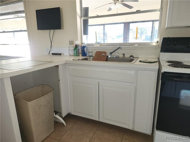 kitchen with sink, light tile patterned floors, electric range, ceiling fan, and white cabinets