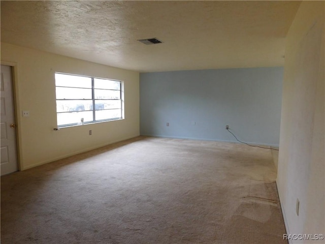 carpeted spare room with a textured ceiling