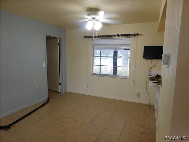 tiled spare room featuring ceiling fan