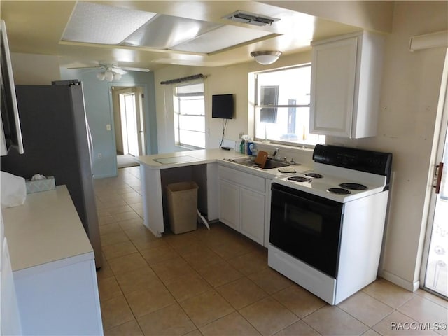 kitchen featuring sink, white cabinets, light tile patterned floors, electric range, and kitchen peninsula