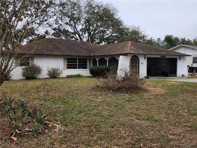 single story home featuring a garage and a front lawn