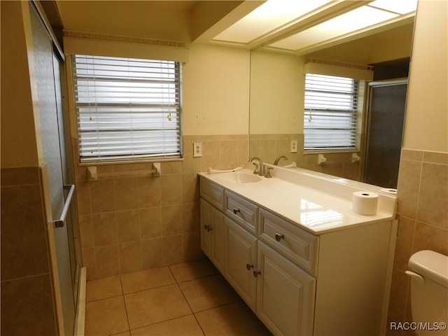 bathroom with tile walls, vanity, tile patterned floors, and toilet