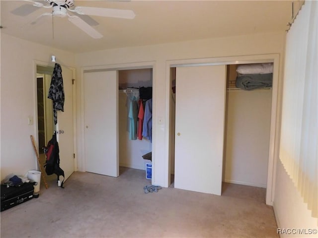 unfurnished bedroom with two closets and ceiling fan