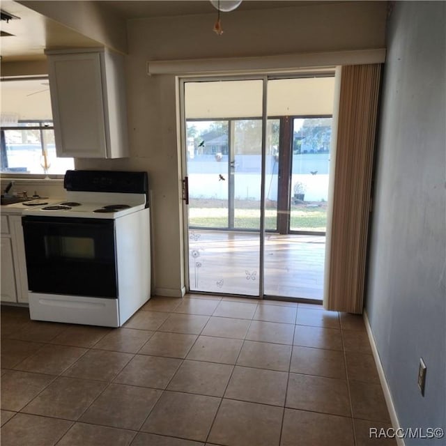 kitchen featuring white cabinetry, tile patterned floors, and range with electric cooktop