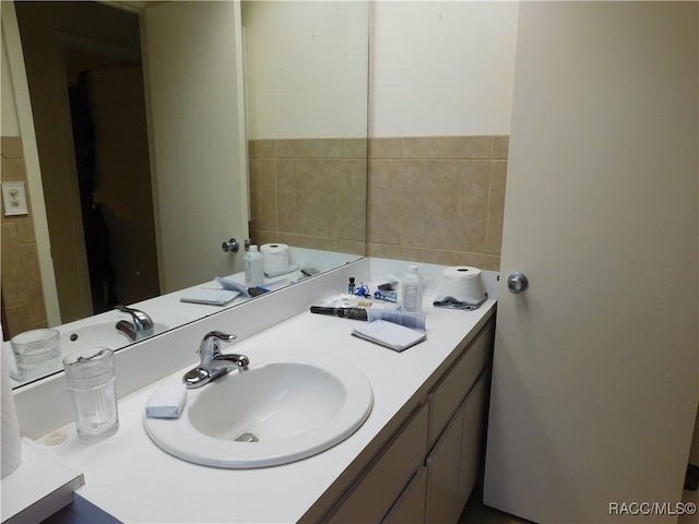 bathroom featuring vanity and tile walls