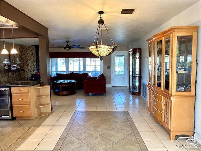 interior space with ceiling fan, beverage cooler, and indoor bar